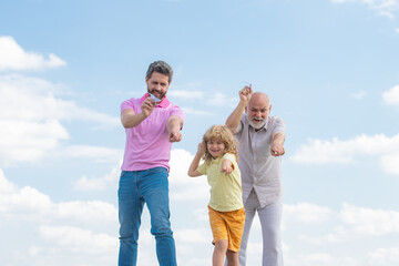 Generations of men together, portrait of smiling son, father and grandfather with a toy airplane. Child boy playing with plane and dreaming future.