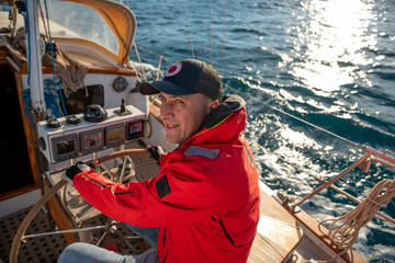 Man steering yacht on the bay of Alicante, Costa Blanca, Spain