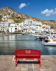A colorful red bench facing the port of Sant’Angelo d’Ischia, Italy