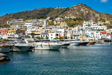 Fototapeta na wymiar Fishing boats and speedboats moored at the colorful port of Sant’Angelo d’Ischia, Italy
