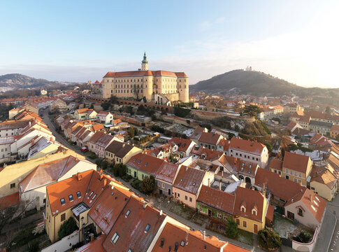 Aerial view of Zamek Mikulov castle with residential district in foreground in wintertime with snow in Mikulov, Czech Republic.