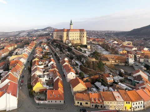 Aerial view of Zamek Mikulov castle with residential district in foreground in wintertime with snow in Mikulov, Czech Republic.