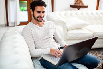 Young man relaxing on the sofa with a laptop