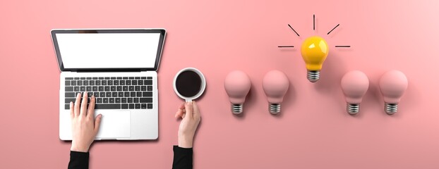 Idea light bulbs with person using a laptop computer from above