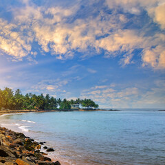 Fototapeta na wymiar Beautiful sunrise over a tropical beach with palm trees.