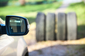 Side mirror of car against four tyres, seasonal wheel and tire changing