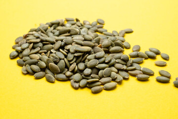 Pumpkin seed on a yellow background close-up.