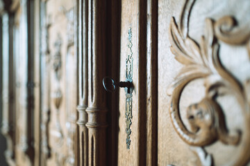 black key in the lock of an old wooden cabinet