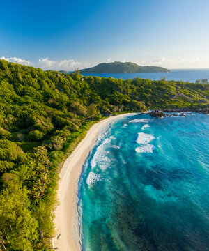 Panoramic aerial view of a scenic beach with white sand facing Anse Cocos Bay, La Digue and Inner Islands, Seychelles.