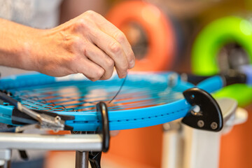 manual stringing of a tennis racket in service