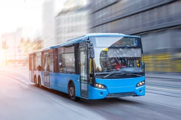 Foto op Plexiglas Blue bus moving on the road in city in early morning. © aapsky