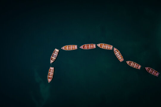 Aerial view of boats anchored along the Lago Di Braies lake, Dolomites, Italy.