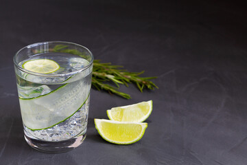 mojito cocktail on black.Cucumber water with lime and rosemary. glass of Homemade flavoured lemonade on the black table. detox water. cold summer lemonade with copy space.