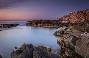 lighthouse on the coast by sunset