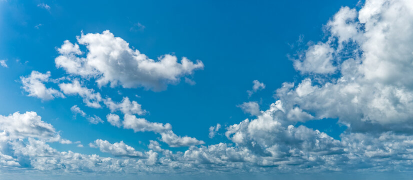 Daytime blue sky Background with white cumulus clouds . Panoramic cloudscape. © Photobes