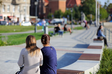 Dwie kobiety siedzą na ławkach nad rzeką Odrą we Wrocławiu.	
