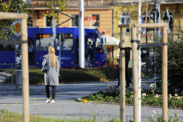 Kobieta blondynka spaceruje chodnikiem w centrum miasta Wtocław. - obrazy, fototapety, plakaty
