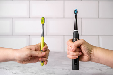 Electric and regular toothbrush in a bathroom. Dental care. Manual toothbrush against modern electric toothbrush concept.