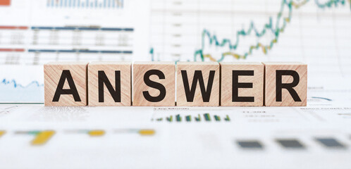 ANSWER Wooden cubes with letters on white background with charts and diagrams