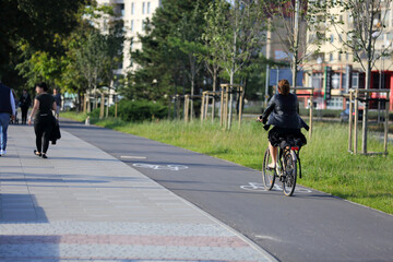 Młoda kobieta jedzie na rowerze po ścieżce rowerowej we Wrocławiu.	
 - obrazy, fototapety, plakaty