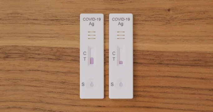 Progress of two Coronavirus antigen tests, side by side. One test becomes positive and one negative. Covid-19, self at home tests.