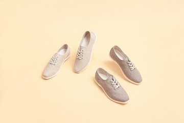 Stylish gray color sneakers isolated on beige background; space for text; perspective view