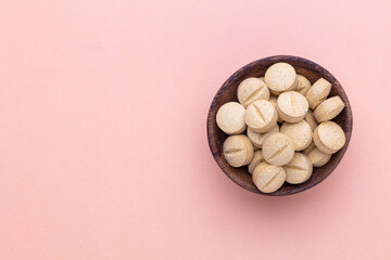 Alternative medicine tablets on a wooden spoon.