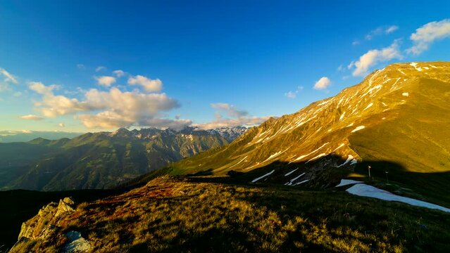 Dramatic sunset over mountains in Switzerland. Majestic mountains in warm golden light during sunset in Swiss Alps.