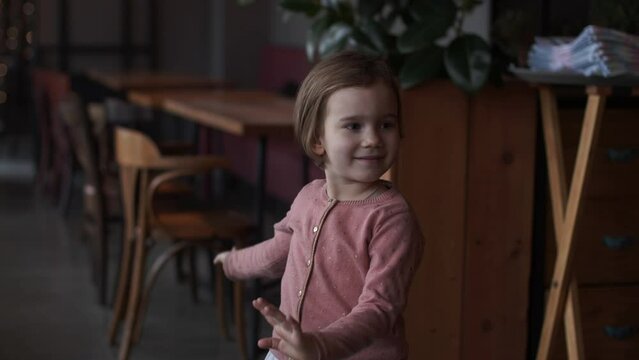 little girl dancing in a cafe