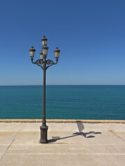 Retro street lanterns in front of a deep blue sea and sky on the coast of Cadiz, Andalusia, Spain  © Kristof Lauwers