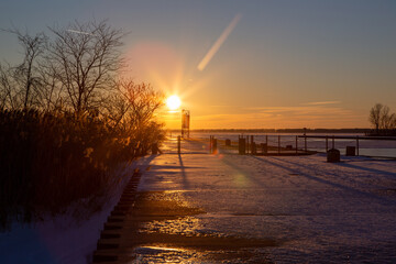 golden sunset along lake pier during a sunny winter day
