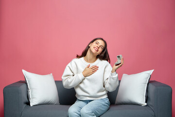 Happy young woman hold gift box with engagement ring surprised by receiving marriage proposal, sitting on sofa