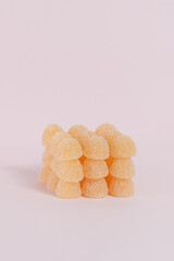 Sweets in the shape of cube on pink background, copy space.