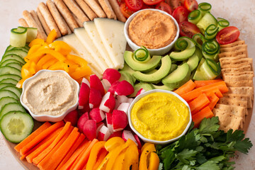 Colorful vegan Charcuterie board with raw vegetables and whole wheat snacks