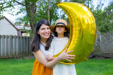 A portrait of young mother with a small daughter in summer