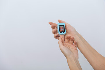 Pulse oximeter with hand of doctor isolated on white. The concept of portable digital device to measure person's oxygen saturation. Measuring oxygen saturation, pulse rate and oxygen levels.
