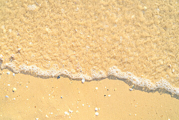 Sand with stones and sea water top view background