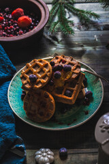 Croissant Waffle or Croffle with srawberry and blueberry sauce served in plate and dark background. Close up, copy space.