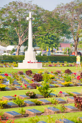 Fototapeta na wymiar War Memorial Cross and Lines of Graves at Kanchanaburi War Cemetery, Thailand, Southeast Asia