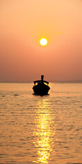 Naklejka na ściany i meble Panoramic Photo of a Traditional Thai Boat Silhouetted at Sunrise at East Railay Beach, South Thailand, Southeast Asia
