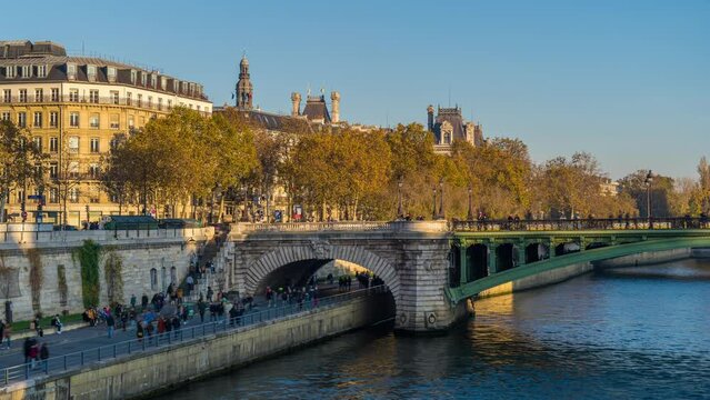 Tourists in Paris Walking on the Seine Docks With Fall Colors, Historic Bridge and Buildings