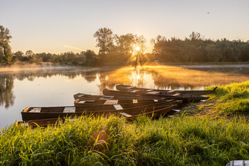 Wschód słońca nad Bugiem z łódkami