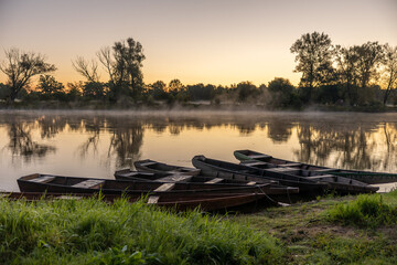 Wschód słońca nad Bugiem z łódkami
