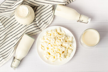 Fresh dairy products, wheat, white wood background, top view