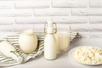 Fresh dairy products, wheat, white wood background, top view