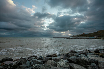 Fototapeta na wymiar dramatic sky over the black sea with waves, clouds and stones