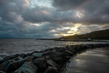 dramatic sky over the black sea with waves, clouds and stones