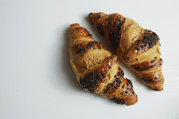 Tasty golden croissants on light background