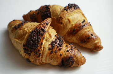 Tasty golden croissants on light background