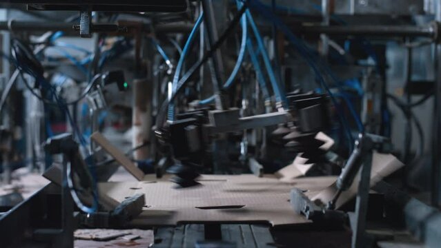 Closeup cardboard packing machine working process at technological facility